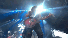 a man playing a guitar in front of a sign that says slash on it