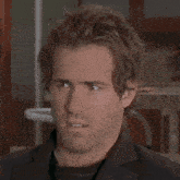a close up of a man 's face with a slight smirk on his face