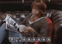a man is sitting on a couch with a cup of coffee in his hand .