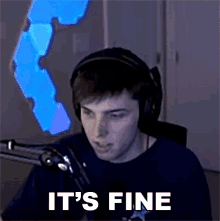 a man wearing headphones says it 's fine in front of a microphone .