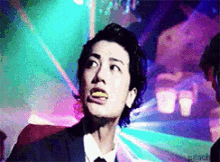 a man in a suit and tie is making a funny face with his mouth open