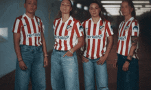 four women wearing red and white striped shirts with herbalife on the front