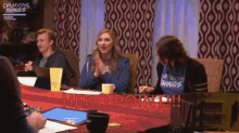 a group of people sitting around a table with the word hero point written on the table