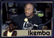 a man wearing headphones stands in front of a microphone with the name ikemba written below him