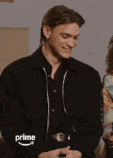a man wearing a black jacket with the word prime written on the sleeve