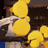 a yellow rubber duck with a crown on its head is being held by a man in a suit