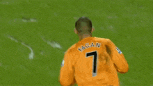 a man in an orange jersey with the number 7 on the back