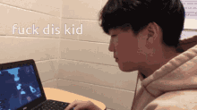 a man sitting in front of a dell laptop with the words " fuck dis kid " written above him