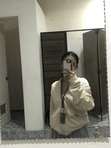 a woman taking a picture of herself in a bathroom