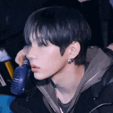 a close up of a person 's face with a fan in the background