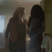 two women are standing next to each other and talking