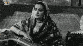 a black and white photo of a woman playing a musical instrument with a logo for gktv in the corner