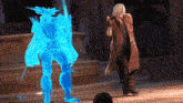 a man in a red coat is standing next to a blue glowing monster