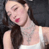 a close up of a woman wearing a pearl necklace and earrings