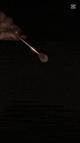 a person is holding a brush in front of a pile of glitter with the number 00 on the bottom