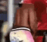 a blurry picture of a man in a red shirt and pink pants