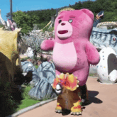a pink teddy bear standing next to a dinosaur