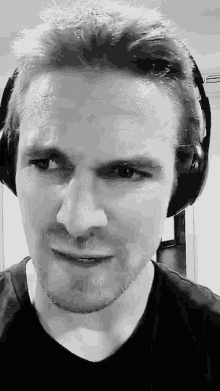 a man wearing headphones is sweating and looking at the camera