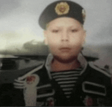 a young boy wearing a black beret and a striped jacket .