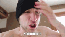 a man without a shirt is wearing a black beanie and making a funny face with the words noooooo !!! below him