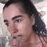 a woman drinking a glass of water with her mouth open
