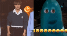 a man in a sweater is standing next to a blue monster with smiley faces on it 's face .
