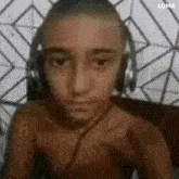 a shirtless young man wearing headphones is sitting in a chair .