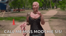 a woman in a black dress is walking down a path and holding a pink shoe .
