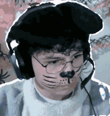 a person with a cat face painted on their face wearing headphones