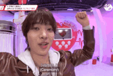 a man with his fist in the air is wearing a brown jacket