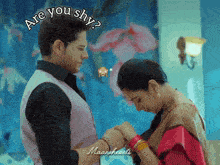 a man and a woman are holding hands and the words are you shy are above them