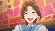 a girl in a blue and white uniform is smiling with her eyes closed