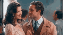 a man and a woman are looking into each other 's eyes and smiling