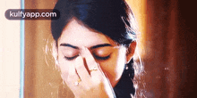 a woman is covering her face with her hand while looking in a mirror .