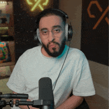 a man with a beard wearing headphones and a white t-shirt
