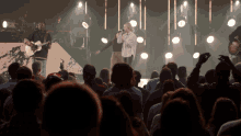 a man playing a guitar and a woman singing on stage in front of a crowd