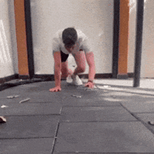 a man is crawling on the floor with his hands on the ground