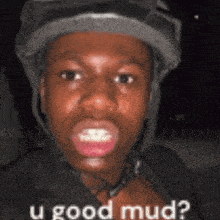 a man wearing a helmet is making a funny face and asking if he is good mud .