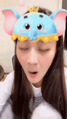a woman wearing a blue elephant mask with a crown