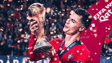 a soccer player is holding a trophy in front of a crowd .