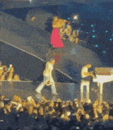 a woman in a pink dress is playing a violin on stage