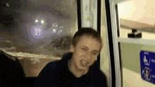 a man is standing in front of a window with a sign on the wall that says ' ambulance ' on it