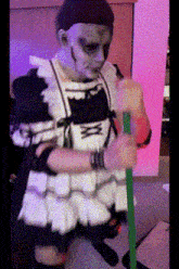 a person in a maid costume holding a green stick