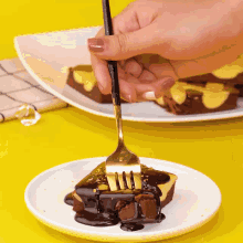 a person holding a fork over a piece of cake on a plate