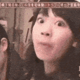 a close up of a woman making a funny face with her eyes closed .