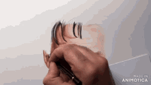 a person is drawing a man 's head with a pencil and the words made in animatica are visible in the corner