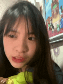 a close up of a girl 's face with a picture behind her