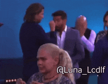 a group of people are standing in front of a blue background and the woman is crying