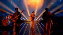 a group of men are playing guitars and singing on stage