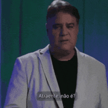 a man wearing a white jacket and a black shirt is talking in a foreign language .